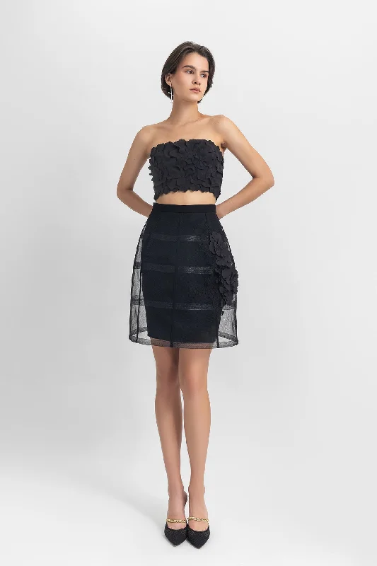Strapless cropped-top with laser-cut details, paired with a cage-like skirt with flower details
 on the side. velvet skirt luxurious